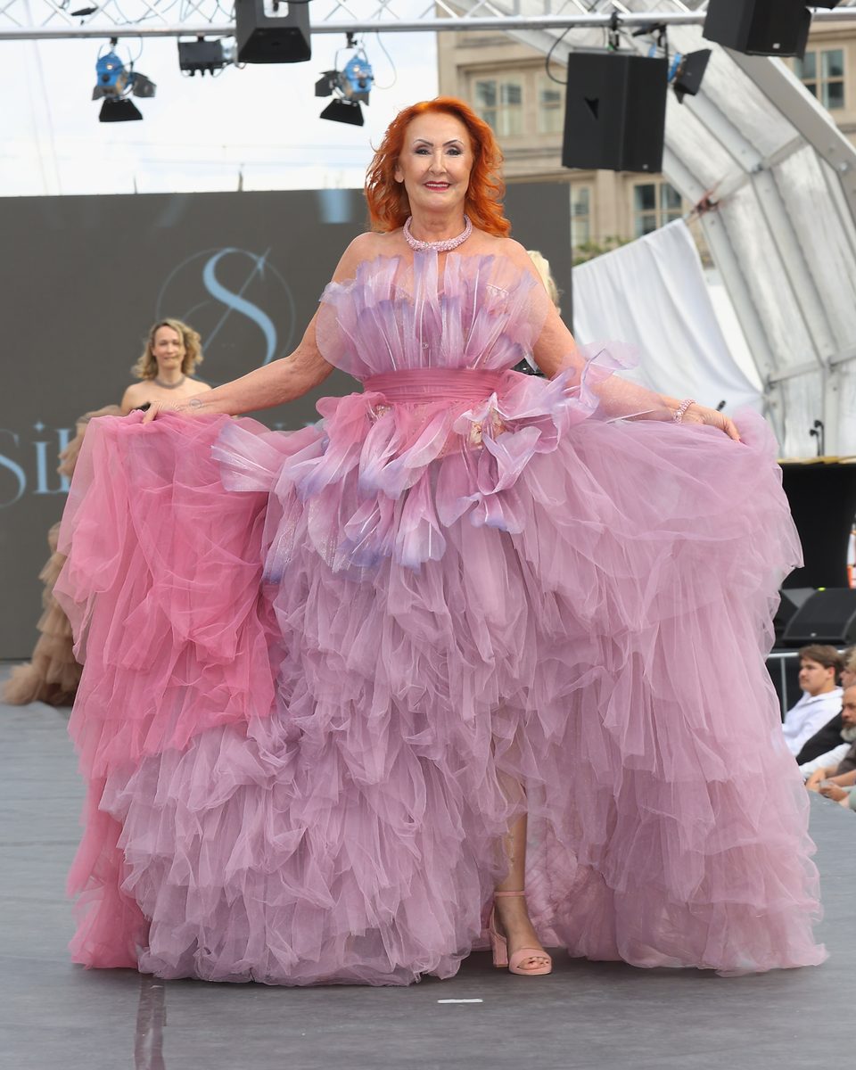 Marietta auf dem Laufsteg der FOA Fashion Week Berlin 2026, den Rock der Tüllrobe von Silbernadel Couture weit gehalten