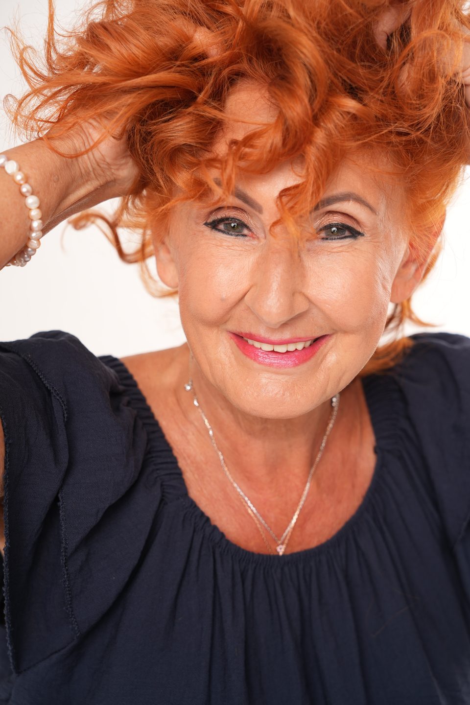 Marietta lacht, beide Hände im roten Haar, Nahaufnahme